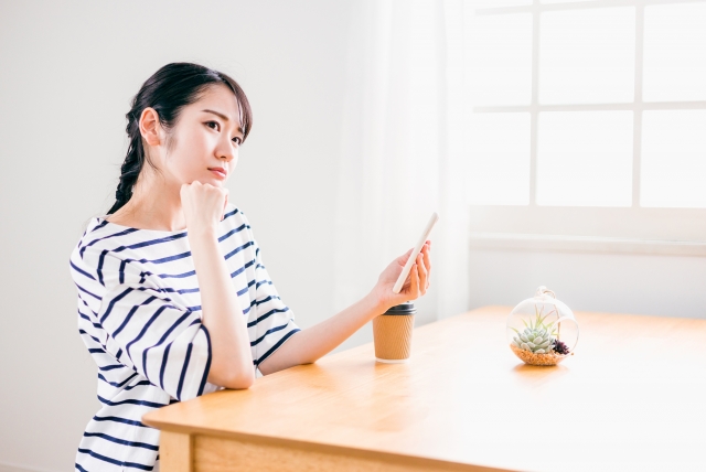 悩んでいる女性の写真